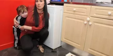 Janine Adams with her little boy Sonny 2,and mouse trap and rat glue traps in her kitchen.